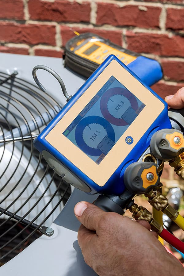 AC and Heater technician is performing preventive maintenance on an AC system.
